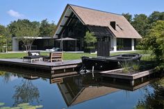 a house that is next to a body of water with a boat in the yard