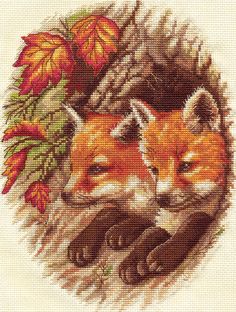 a cross stitch pattern with two foxes laying in the grass and autumn leaves around them