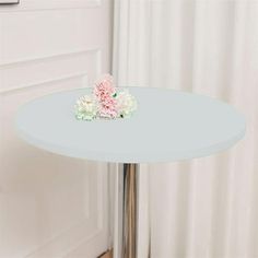 a small white table with flowers on it