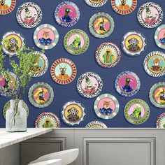 the wallpaper is decorated with colorful plates and flowers in vases on a table