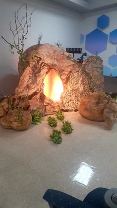 there is a fake fireplace in the middle of this room with rocks and plants growing out of it