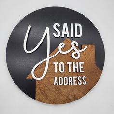 a wooden sign that says said yes to the address on top of a black circle