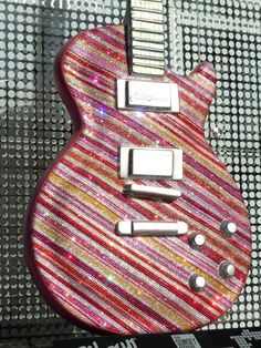 a pink and red guitar sitting on top of a table