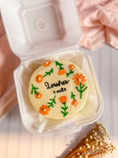 a cake in a plastic container with flowers on it