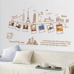 a living room with a white couch and wall decals on the walls that say travel life is easy