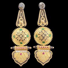 These Antique Gold Long Earrings feature intricate craftsmanship with a beautiful mix of traditional design elements. The earrings showcase a central round motif with green enamel and detailed gold work, radiating an elegant vintage charm. The top of the earrings is highlighted by a polished stone setting, completing the regal aesthetic. Perfect for adding a touch of heritage style to any festive occasion. Material: 92.5 hallmarked silver Stones: Semi precious rubies and emeralds, CZ I'll be happy to do a video call or share more pictures/videos of the earrings on request Return Policy: Given the nature of the product, we are unable to accept any returns or exchanges at this time Gold Ornate Danglers, Ornate Antique Gold Pierced Earrings, Antique Gold Victorian Brass Earrings, Ornate Yellow Gold Brass Earrings, Ornate Gold-colored Sterling Silver Earrings, Long Gold Earrings, Pin Pendant, Heritage Fashion, Gold Work