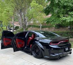 a black sports car with its doors open and the door ajar opened in front of it