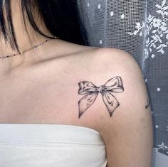 a woman with a bow tattoo on her shoulder