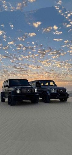 two black jeeps parked in the desert at sunset