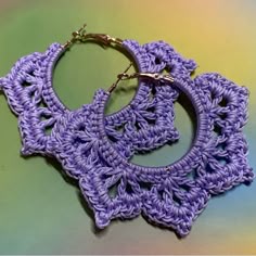 purple crocheted hoop earrings on green background