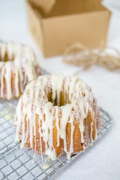 two donuts with icing sitting on a cooling rack