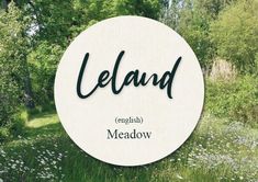 a white circle with the words iceland and meadow in front of some trees, grass and flowers