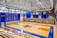 an indoor basketball court with blue and white paint