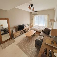 a living room filled with furniture and a flat screen tv on top of a wooden table