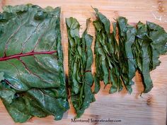 some green leafy vegetables are on a cutting board