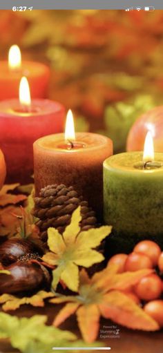 several candles with autumn leaves surrounding them