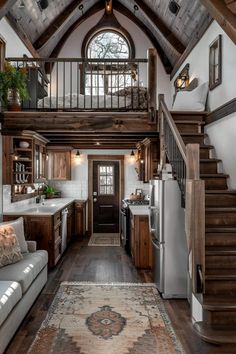 a living room and kitchen area in a home with wood floors, white walls and ceiling