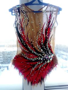 a red and black dress hanging on a window sill