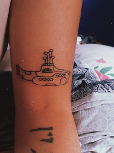 a black and white photo of a tattoo on the arm of a person with a yellow submarine