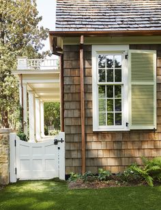 a brown house with white shutters and windows