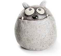 a rock with an animal face and eyes sitting on it's side, in front of a white background