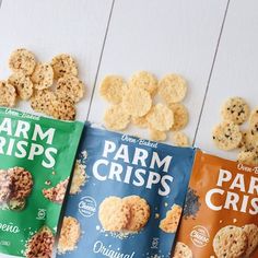 three bags of farm crispes are lined up on a white table with other snacks