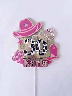 a cake topper with the word karaha on it and a cow in a hat