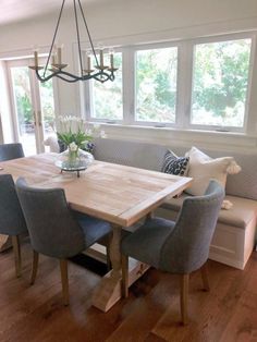 a dining room table with blue chairs and a bench in front of the couches