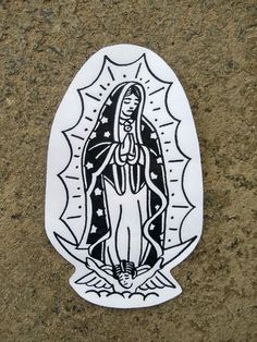 a sticker depicting the virgin mary in black and white on a stone surface with sunbursts