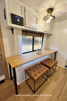 a kitchen with a table, bench and window in the back wall is shown here