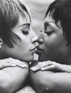 two women kissing each other with their noses close together