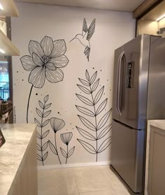 a kitchen wall with flowers and birds painted on the walls, along with a refrigerator