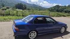 a blue car parked on the side of a road