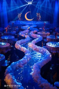 a stage set up for a party with blue lighting and white linens on the floor