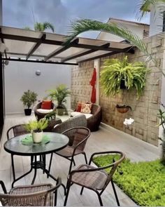 an outdoor patio with chairs, tables and potted plants on the side of it