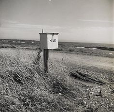 a black and white photo of a sign on the side of a road that says hilk