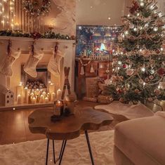 a living room filled with furniture and a christmas tree in front of a fire place