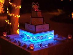 a lit up cake sitting on top of a table