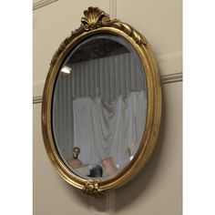 a gold framed mirror hanging on the wall