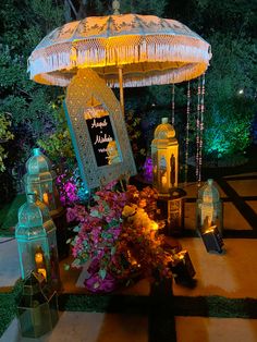 an outdoor area with lanterns, candles and flowers on the ground in front of a gazebo