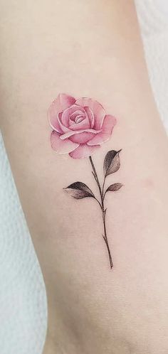 a pink rose tattoo on the back of a woman's stomach