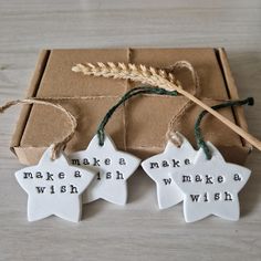 three ceramic stars with words on them sitting in front of a brown box that says make a wish