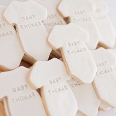 baby shower cookies with white frosting are arranged on a table in front of each other