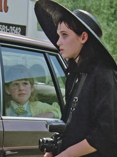 a young boy in a cowboy hat sitting in the driver's seat of a car