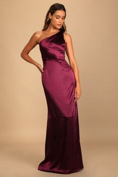 a woman in a long purple dress posing for the camera with her hands on her hips