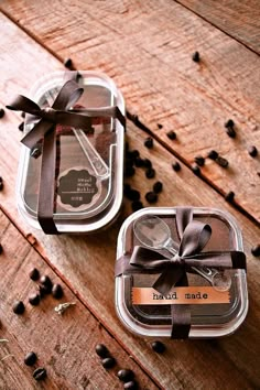 two glass containers filled with coffee beans on top of a wooden table