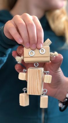 a person holding a wooden toy in their hands