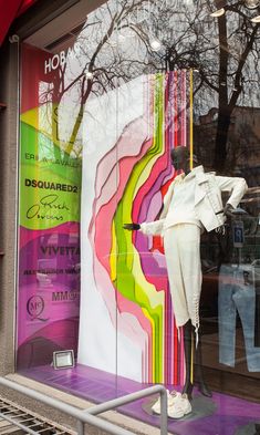 a window display with mannequins dressed in white and multicolored clothing