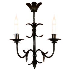 an iron chandelier with three candles on it