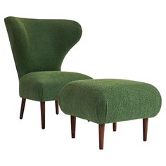 an upholstered green chair and footstool are shown in front of a white background